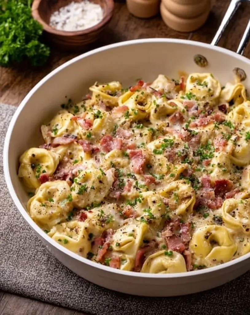 One Pot Tortellini mit Schinken und Speck in cremiger Sauce auf einem Teller