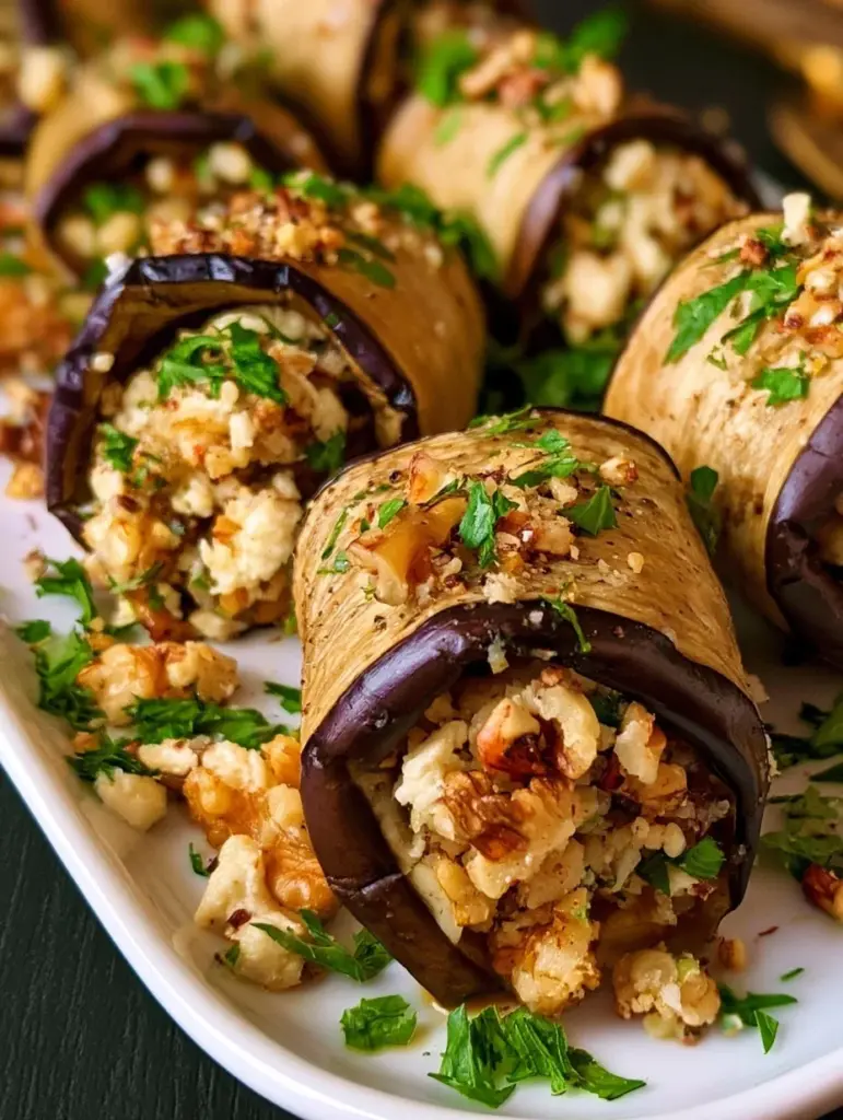 Gegrillte Auberginenröllchen mit Walnuss-Feta-Füllung auf einem Teller serviert