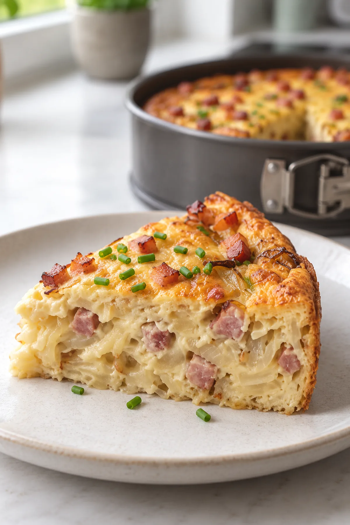 Serviertes Stück High-Protein Zwiebel-Speck-Kuchen mit saftigem Anschnitt und Schnittlauch